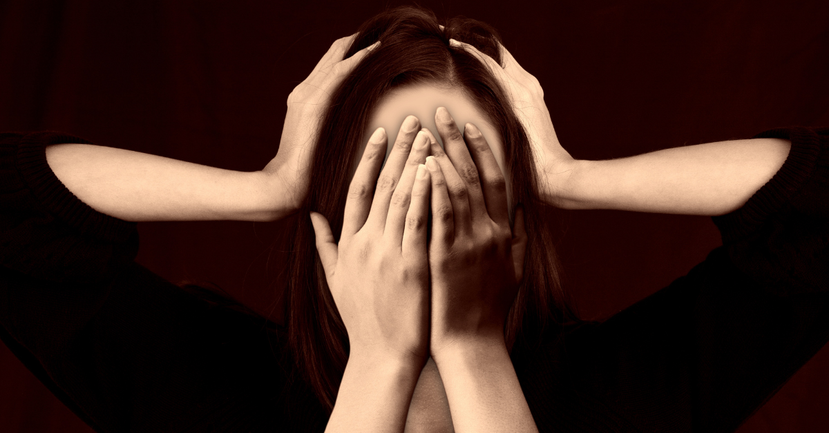 woman holding hands to her head while two other hands cover her face