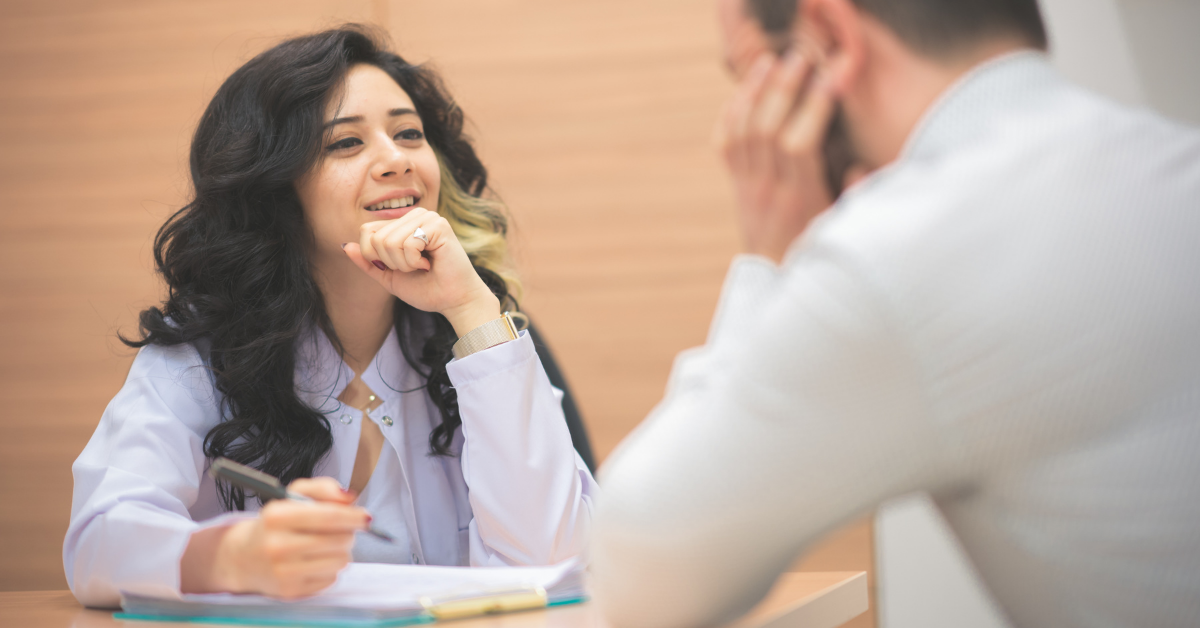 Therapist taking notes while speaking to a patient