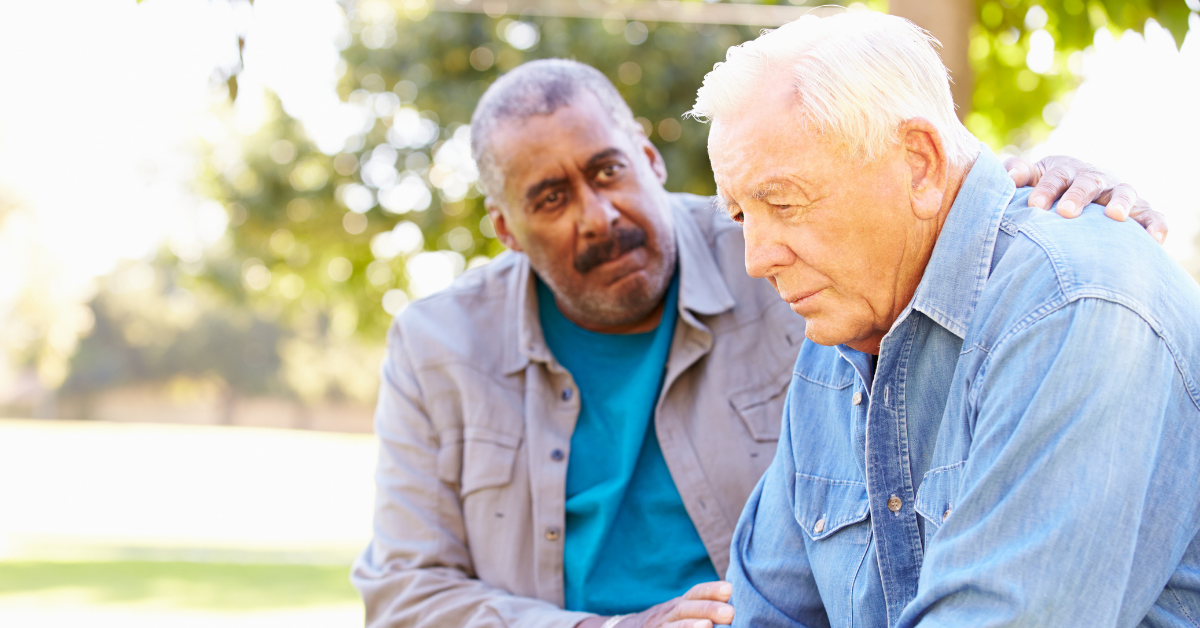 Older men consoling one another in a park