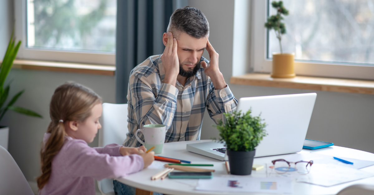 Stressed dad sitting at table with child