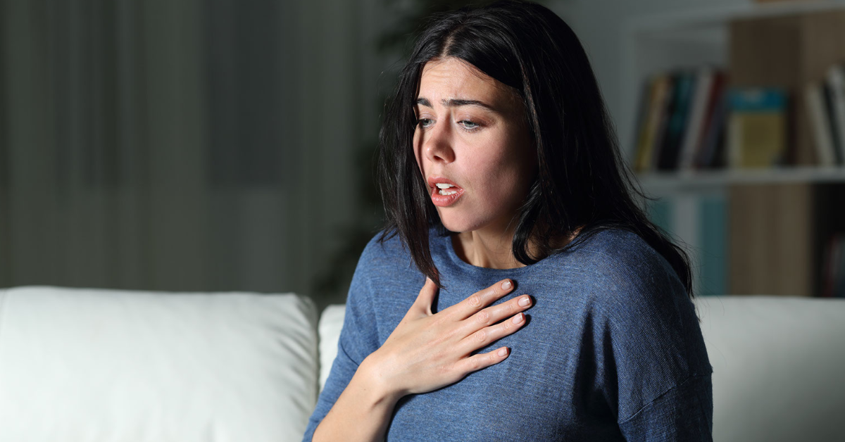 Woman with an uncomfortable expression and her hand on her chest